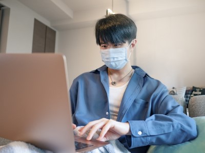 Young asian businessman working from home in quarantine isolation with face mask