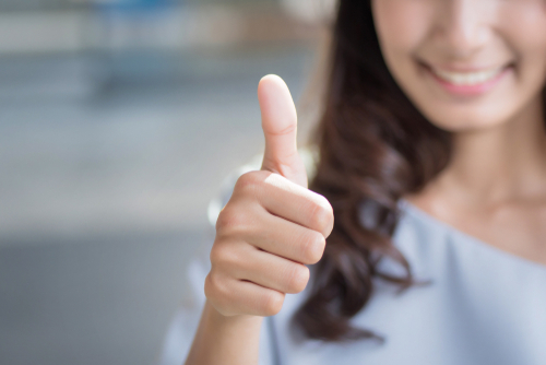 Successful,Girl,Pointing,Thumb,Up;,Portrait,Of,Cheerful,Smiling,Woman
